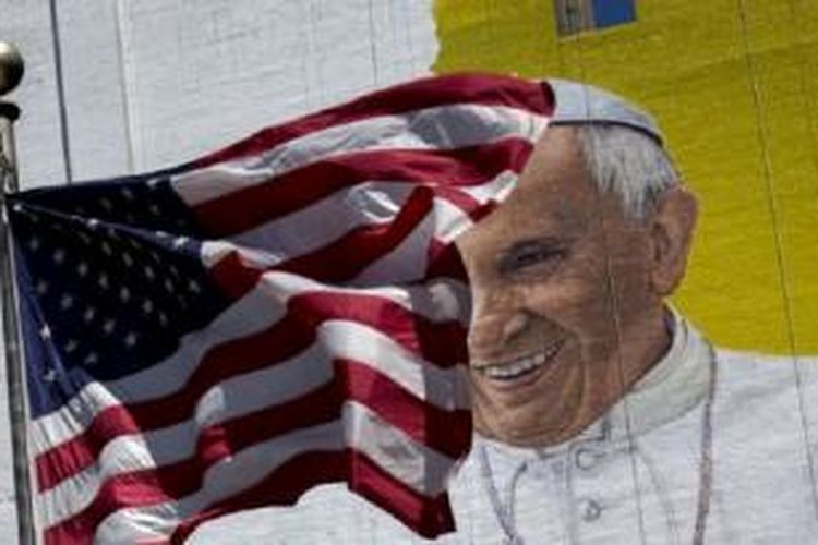 Bendera AS berkibar di depan lukisan dinding Paus Fransiskus di sebuah gedung di pusat kota Manhattan di New York (28/8/2015). 