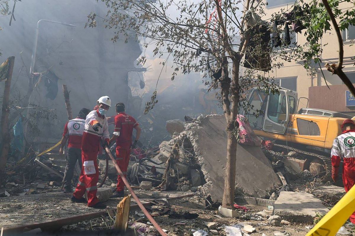Petugas Bulan Sabit Merah Iran menyisir puing-puing bangunan yang hancur dalam serangan Israel di permukiman Ibu Kota Teheran, Iran, Sabtu, 14 Juni 2025.