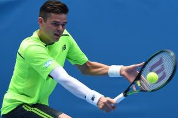 Petenis Kanada, Milos Raonic, memukul bola ke arah petenis Ukraina, Illya Marchenko, pada babak pertama Australia Terbuka di Melbourne Park, Senin (19/1/2015).