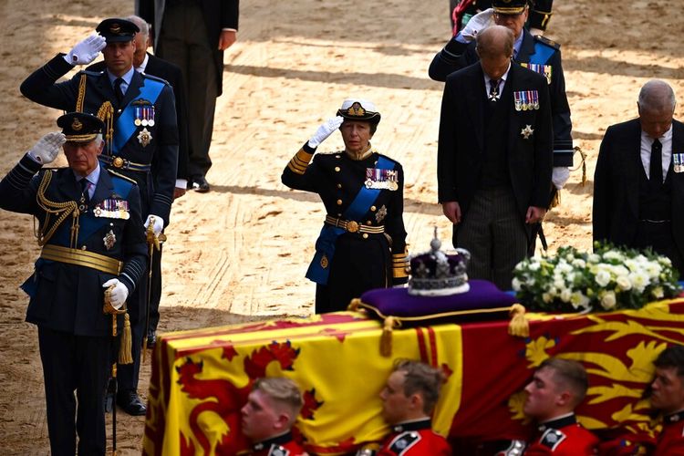 Prosesi pemakaman Ratu Elizabeth II. Raja Inggris Charles III, Pangeran William dari Inggris, Putri Anne dari Inggris, memberi hormat bersama Pangeran Andrew dari Inggris, ketika peti mati Ratu Elizabeth II yang dihiasi simbol Royal Standard dan Mahkota Negara Kerajaan dibawa ke Istana Westminster mengikuti prosesi dari Istana Buckingham, London, Rabu (14/9/2022).