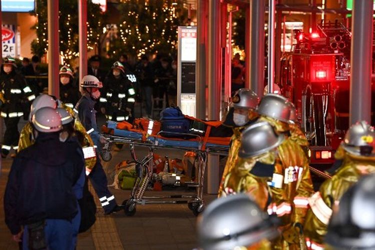 Petugas pemadam kebakaran berkumpul di luar Stasiun Kokuryo di Jalur Keio di kota Chofu di Tokyo barat pada 31 Oktober 2021, setelah seorang pria melukai setidaknya 10 orang dalam serangan pisau dan api di sebuah kereta komuter.