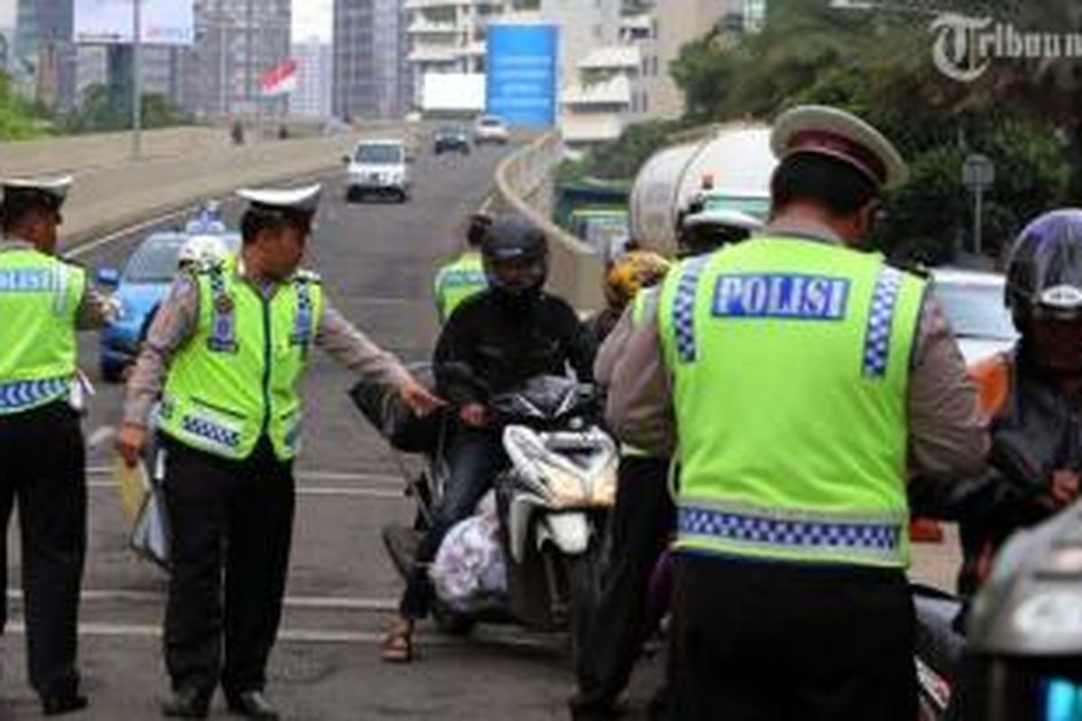 Polisi lalu lintas merazia para pengendara sepeda motor yang nekat melintasi JLNT Kampung Melayu-Tanah Abang di kawasan Karet, Jakarta Pusat, Selasa (28/1/2014). Puluhan pengendara sepeda motor terjaring dalam razia yang dilakukan untuk menekan tingkat kecelakaan. Seharusnya pemotor dilarang melintas JLNT tersebut. 
