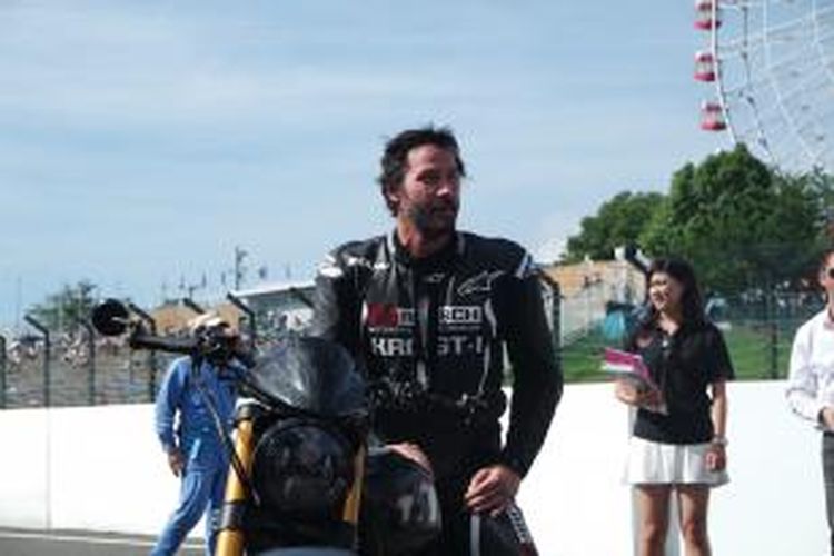 Aktor Amerika Serikat, Keanu Reeves, berpose di atas motornya setelah melakukan dua putaran di Sirkuit Suzuka, Sabtu (25/7/2015). Reeves datang untuk menyaksikan balapan Suzuka 8 Hours 2015.