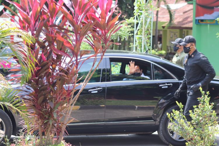 Presiden RI Joko Widodo melambaikan tangan kepada guru dan siswa-siswi yang menyaksikan ketadangannya dari jarak tertentu usai meninjau pelaksanaan vaksinasi pelajar di SMA Negeri 2 Bandar Lampung, Kamis, (2/9/2021). 
