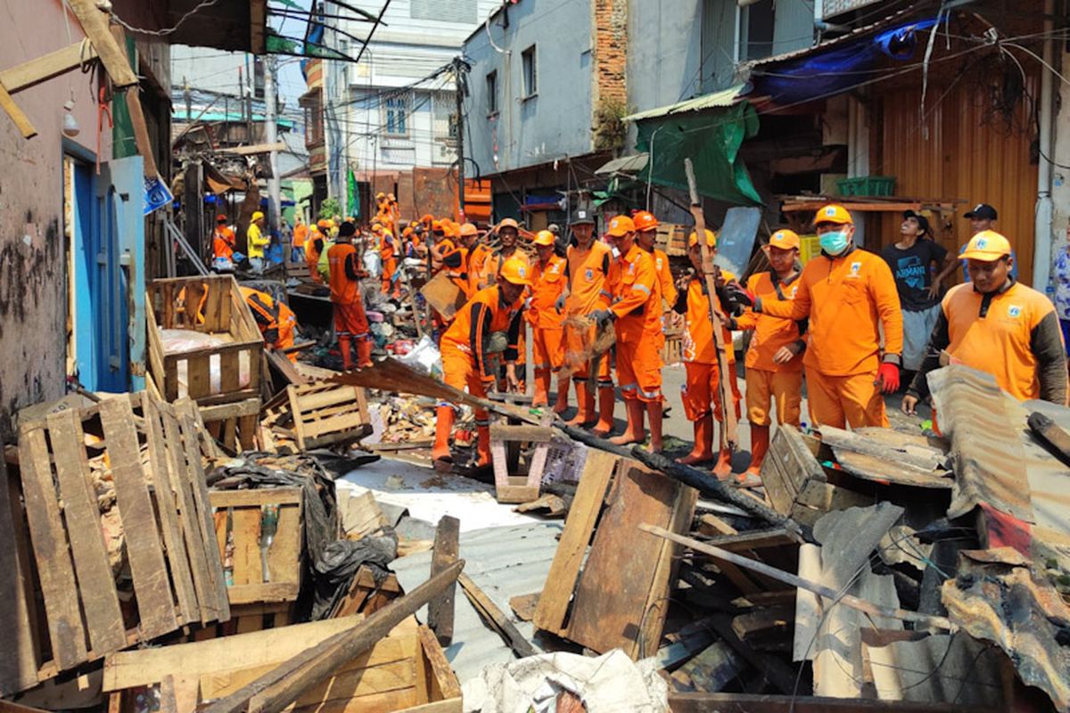 Ratusan petugas gabungan dari lintas perangkat daerah dikerahkan melakukan aksi bersih-bersih di lokasi bekas kebakaran RW 02, Kelurahan Duri Utara, Kecamatan Tambora, Jakarta Barat, Selasa (22/7/2025).