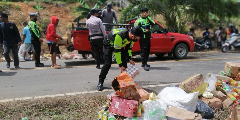 Petugas Satlantas Polres Nunukan bersama warga membantu menyingkirkan minuman bersoda muatan mobil pickup yang alami laka lantas dan menewaskan seorang pengendara motor di Pulau Sebatik Nunukan Kaltara