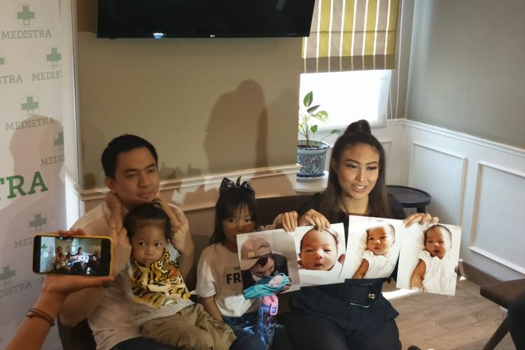 Ayu Dewi bersama suami dan anaknya sambil menunjukan foto anak ketiganya dalam jumpa pers di RS Medistra, Kuningan, Jakarta Selatan, Jumat (4/10/2019).