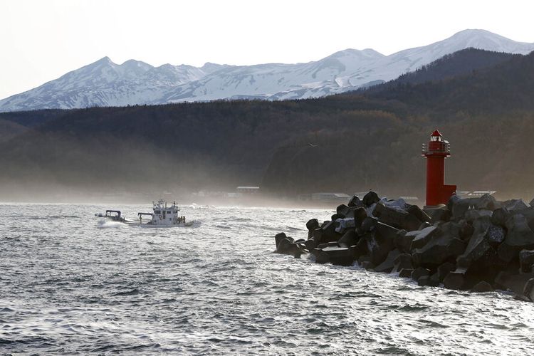 A fishing boat leaves a port in Shari, in the northern island of Hokkaido Sunday, April 24, 2022. The Japanese Coast Guard said Sunday that their helicopters found four of the 26 people on a tour boat, which left the port and went missing since the day before. (Kyodo News via AP)