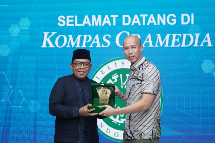 CEO KG Media Andy Budiman (kanan) menerima Plakat MUI dari Ketua Bidang Informasi dan
Komunikasi sekaligus Ketua Steering Committee Munas XI KH Masduki Baidowi di Bentara Budaya Art Gallery, Menara Kompas, Selasa (18/11/2025).