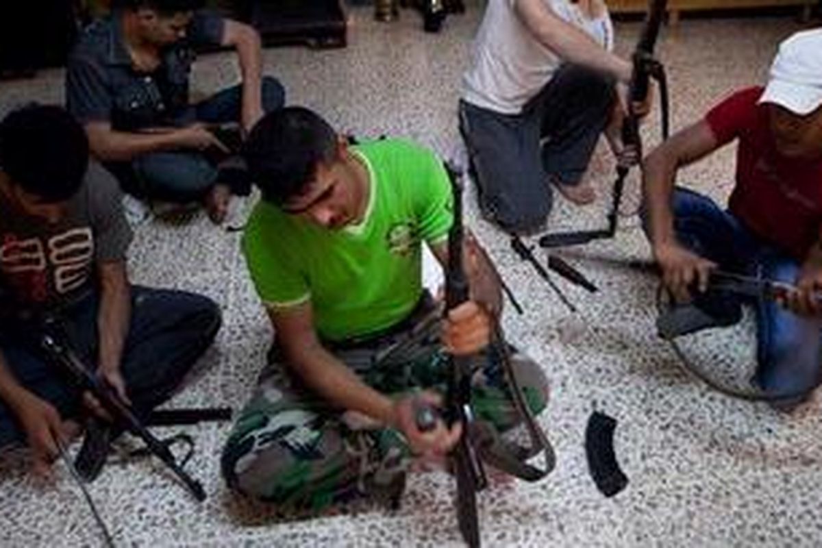 Petempur yang loyal pada Tentara Pembebasan Suriah (FSA) mempersiapkan senjata masing-masing di markas mereka di pinggiran Kota Idlib, wilayah barat laut Suriah, Senin (18/6/2012). 