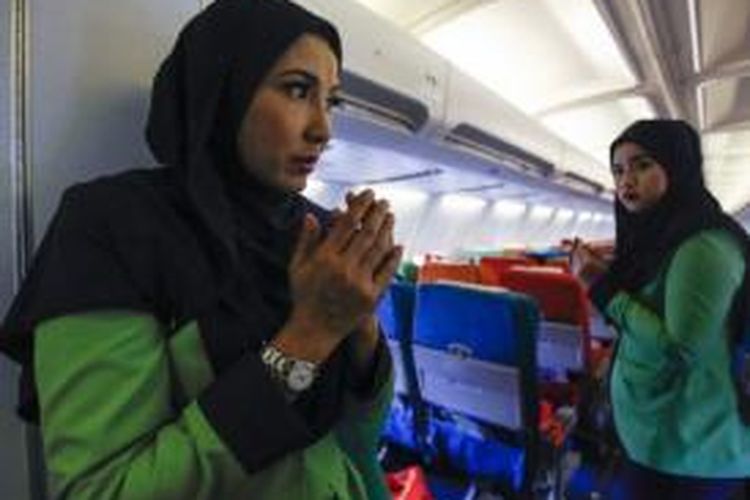 Pramugari Rayani Air terlihat berdoa sebelum pesawat lepas landas. 
