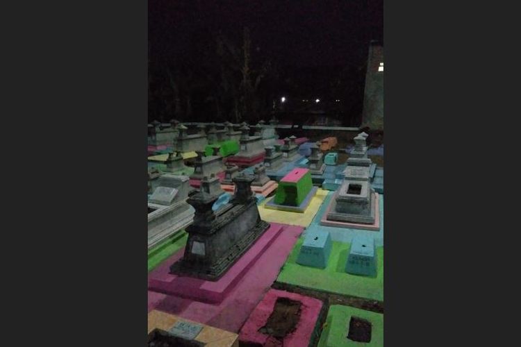 Kondisi makam warna-warni di malam hari diterangi sejumlah lampu neon yang terpasang.
