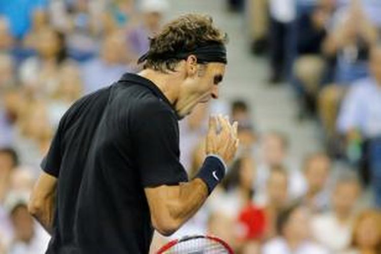 Petenis Swiss, Roger Federer, berteriak setelah meraih poin atas petenis Perancis, Gael Monfils, pada babak perempat final AS Terbuka di USTA Billie Jean King National Tennis Center, Kamis 94/9/2014).