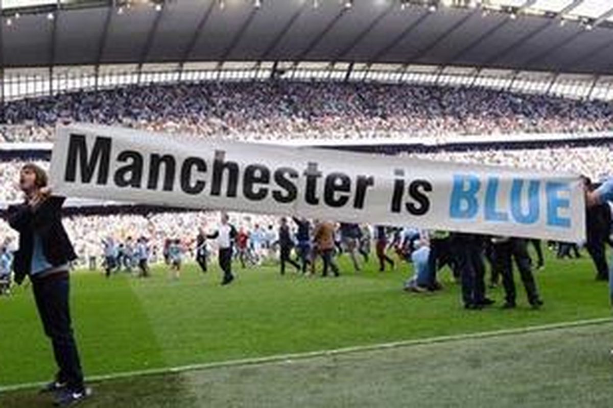 Suporter Manchester City membentangkan spanduk "Manchester is blue" setelah timnya menang 3-2 atas Queens Park Rangers, Minggu (13/5/2012), sekaligus juara Premier League 2011-12.
