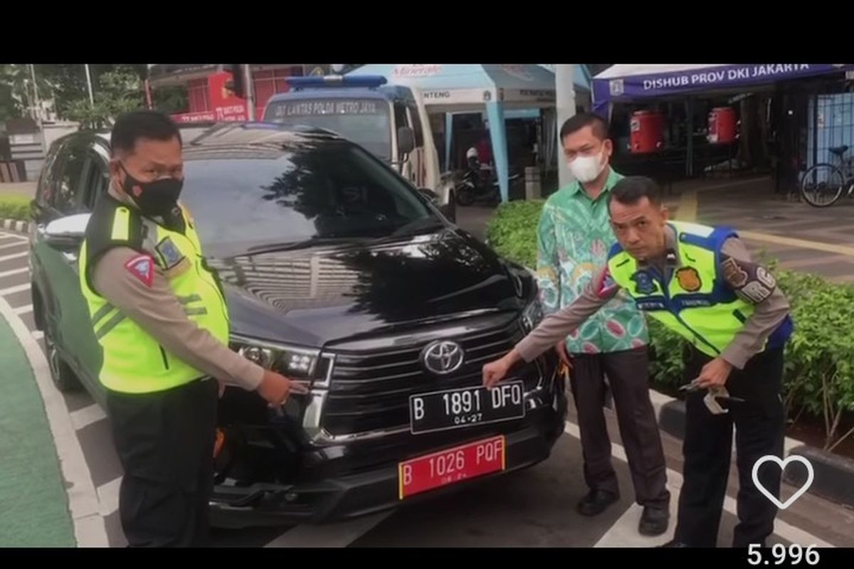 Tangkapan layar video pengemudi mobil diberhentikan petugas di kawasan Bundaran HI, karena pakai pelat dinas bodong, Jumat (16/12/2022). 