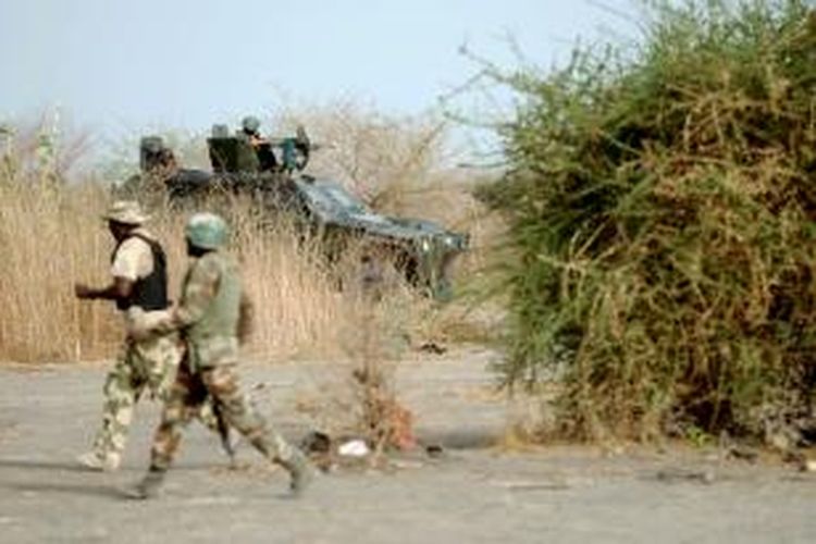 Foto yang diambil pada 5 Juni 2013 ini memperlihatkan prajurit angkatan darat Nigeria berpatroli di dekat kota Maiduguri, negara bagian Borno, basis terkuat kelompok militan Boko Haram.