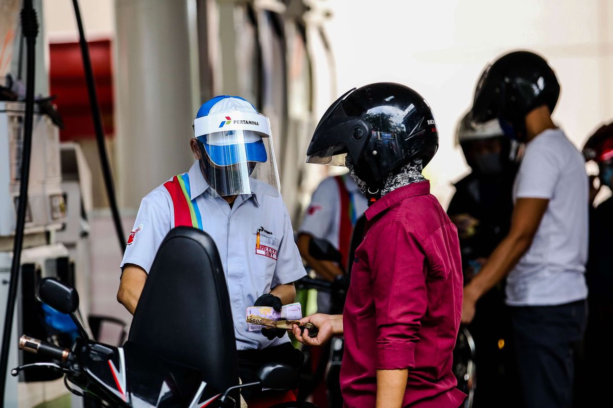 Petugas SPBU menggunakan alat pelindung wajah saat melayani pengendara di SPBU Pertamina 31.128.02 di Jl. Letjen M.T. Haryono, Jakarta Timur, Senin (1/6/2020). Penggunaan alat pelindung wajah (Face Shield) tersebut sebagai salah satu upaya untuk melindungi diri saat berhubungan langsung dengan pengendara dalam pencegahan penyebaran COVID-19.