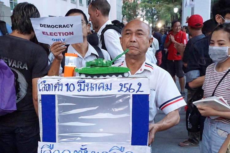 Seorang pria peserta aksi unjuk rasa mendesak digelarnya pemilihan umum yang demokratis di Thailand.