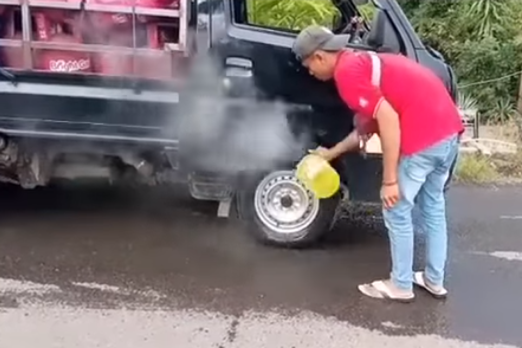 Tangkapan layar video pengemudi mobil pikap menyiram rem mobilnya yang panas dengan air.