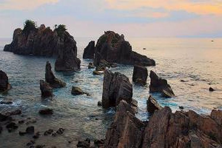 Batuan tebing menjulang tinggi di perairan Pantai Pegadungan, Kabupaten Tanggamus, Lampung. Karena bentuknya, sebagian orang menyebutnya Gigi Hiu, sebagian orang lain menyebutnya Batu Layar. Lokasi ini menjadi salah satu tempat favorit bagi fotografer yang mengabadikan keindahan alam di sana. 

