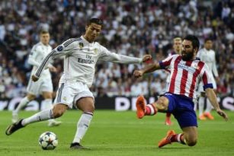 Penyerang Real Madrid, Cristiano Ronaldo (kiri), mendapatkan hadangan dari gelandang Atletico Madrid, Arda Turan, pada pertandingan leg kedua perempat final Liga Champions, di Santiago Bernabeu, Rabu atau Kamis (23/4/2015) dini hari WIB. 