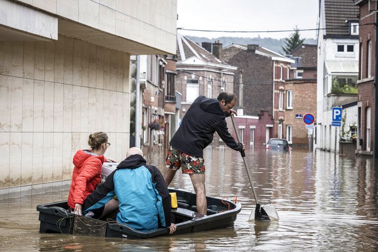 Viernes, 16 de julio de 2021 Un hombre recoge un bote en una calle residencial después de las inundaciones en Anglo, Bélgica.