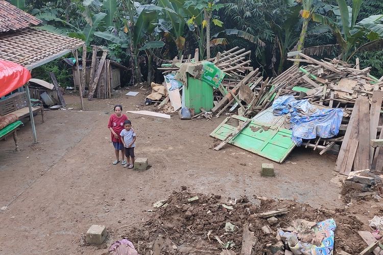 Jumini (65) di tengah puing rumah yang han ur akibat tanah longsor di Pedukuhan Plampang II, Kalurahan Kalirejo, Kapanewon Kokap, Kabupaten Kulon Progo, Daerah Istimewa Yogyakarta, Jumat (1/6/2022) malam.