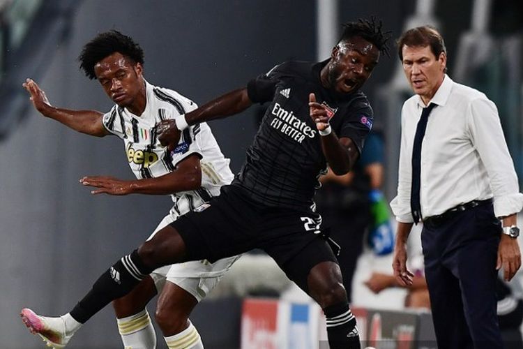 Juan Cuadrado (kiri) berduel dengan Maxwell Gnaly Cornet (kanan) dalam laga leg kedua babak 16 besar Liga Champions Juventus vs Lyon di Stadion Allianz, Sabtu (8/8/2020) dini hari WIB. 