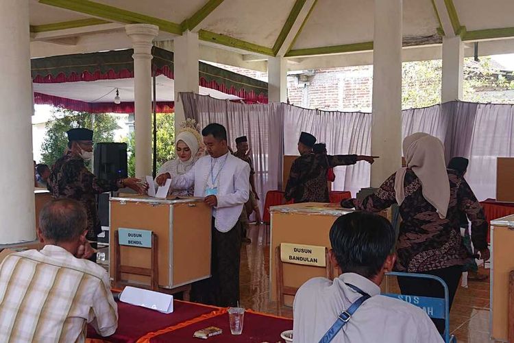 Pakai baju pengantin, pasangan ini memberikan hak pilih dalam pemilihan kepala Desa Wonocoyo Kecamatan Pogalan Trenggalek, Rabu (25/10/2023)