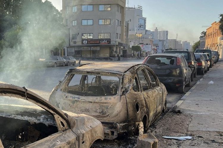 Kendaraan yang rusak terlihat di sebuah jalan di ibu kota Libya, Tripoli, pada 27 Agustus 2022, menyusul bentrokan antara kelompok saingan Libya. 