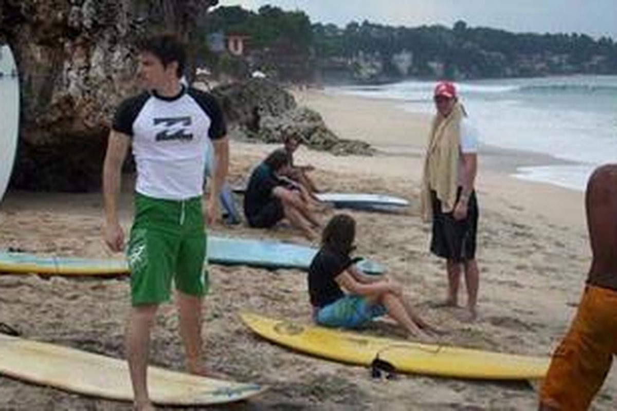 Wisman siap-siap surfing di pantai Dreamland, Bali.
