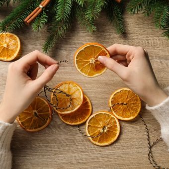 ilustrasi membuat karangan bunga Natal dari jeruk kering