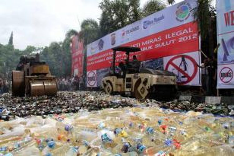 Alat penggilas sedang menghancurkan puluhan ribu botol minuman keras yang dimusnahkan di Halaman Mapolda Sulut. Minuman keras tersebut merupakan barang bukti sitaan dari beberapa operasi yang digelar Polda Sulut.
