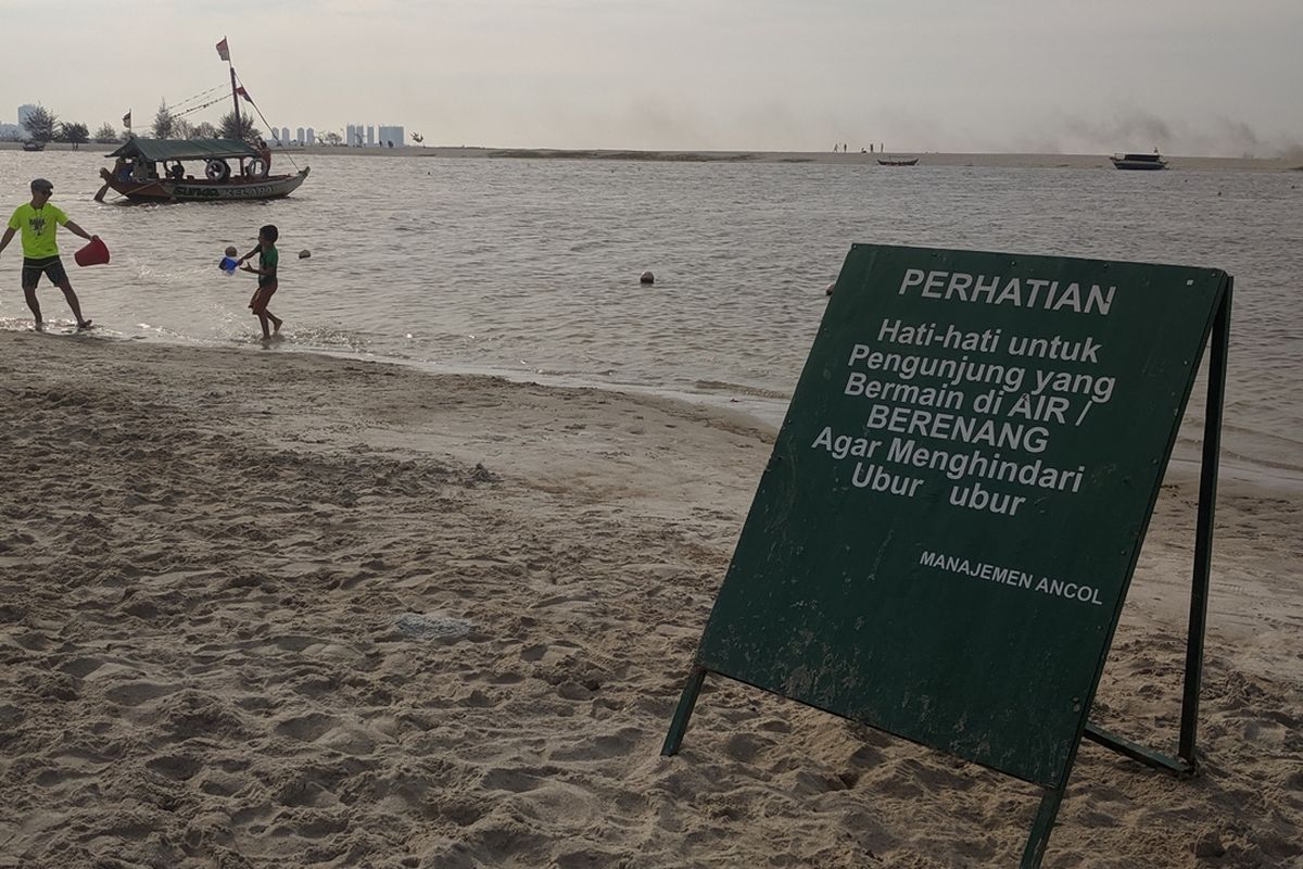 Imbauan agar warga menjauh dari ubur-ubur yang berenang ke pinggir Pantai Ancol Taman Impian, Pademangan, Jakarta Utara, Senin (7/10/2019)