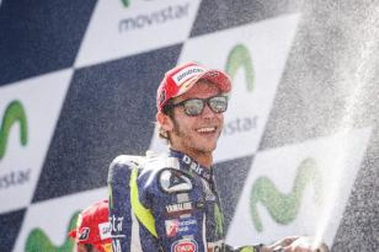 Pebalap Movistar Yamaha asal Italia, Valentino Rossi, merayakan hasil finis ketiga pada balapan GP Aragon di atas podium Sirkuit MotorLand, Minggu (27/9/2015).