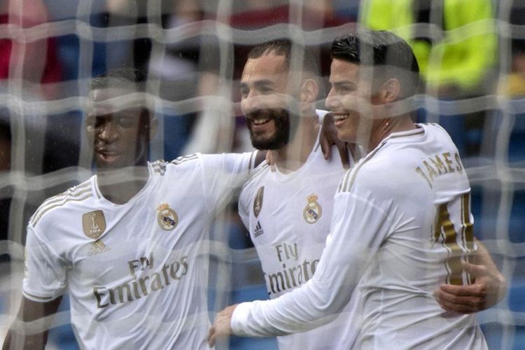 Penyerang Real Madrid, Karim Benzema (tengah), merayakan golnya dengan rekan setimnya James Rodriguez (kanan) dan Vinicius Junior, setelah mencetak gol melawan Levante UD di Stadion Santiago Bernabeu, Sabtu (14/9/2019). 