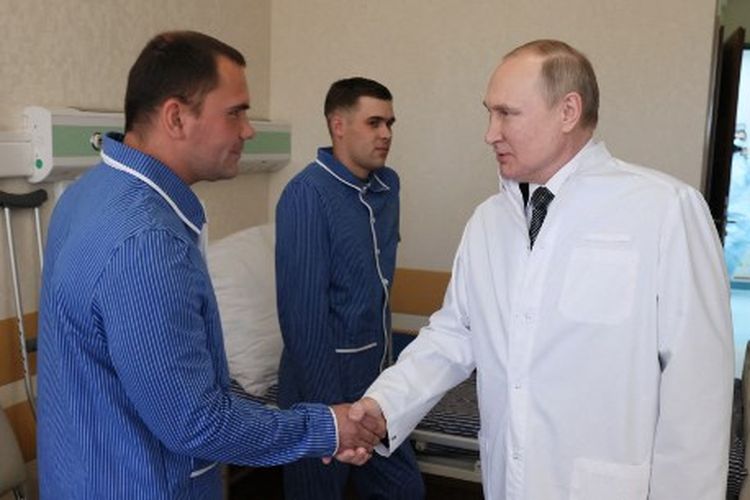 Presiden Rusia Vladimir Putin mengunjungi prajurit yang terluka dalam aksi militer Rusia di Ukraina, di sebuah rumah sakit militer di Moskow pada 25 Mei 2022.