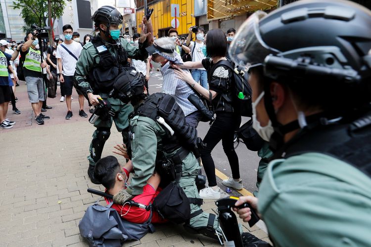 Seorang demonstran penentang pemerintah berjibaku dengan polisi anti huru-hara dalam demonstrasi di tengah pembahasan rancangan aturan untuk menghukum penghina lagu kebangsaan China di Hong Kong, pada 27 Mei 2020.