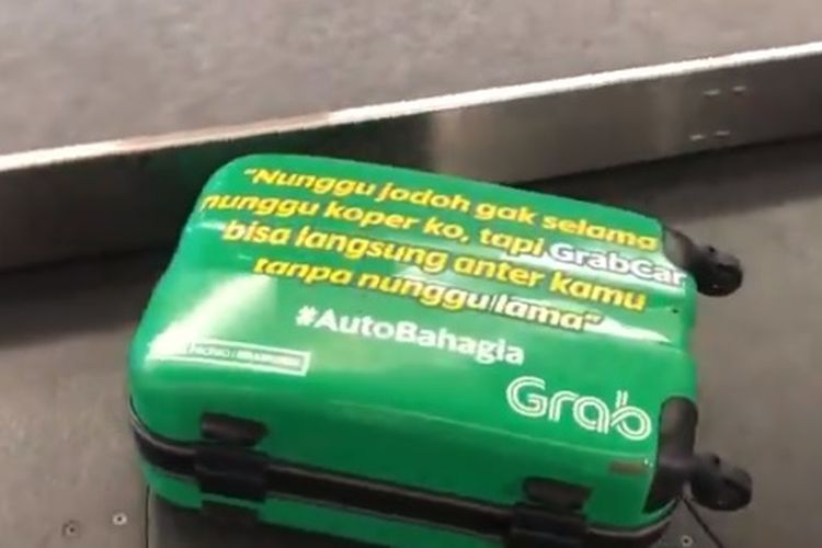 Grab Indonesia bikin iklan kreatif agar pengunjung tidak bosan menunggu koper di bandara Husein Sastranegara, Bandung.