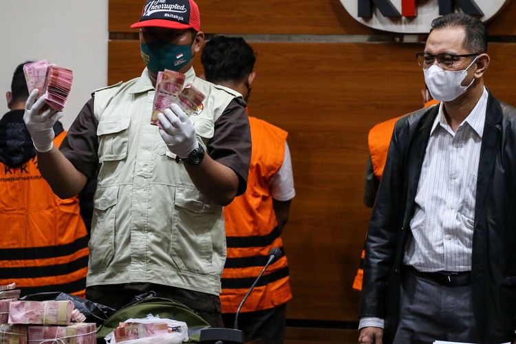 Petugas menunjukkan barang bukti disaksikan oleh Wakil Ketua KPK Nurul Ghufron (kanan) saat konferensi pers terkait penetapan tersangka di Gedung KPK, Jakarta, Kamis (20/1/2022). KPK resmi menahan Bupati Langkat Terbit Rencana Perangin Angin bersama lima orang lainnya serta mengamankan barang bukti berupa uang sebesar Rp 786 juta terkait pekerjaan pengadaan barang dan jasa tahun 2020 sampai 2022 di Kabupaten Langkat, Sumatera Utara.