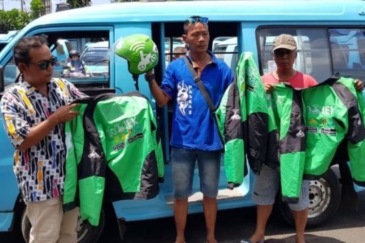 Awak angkot Salatiga menunjukkan helm dan jaket yang disita dari pengemudi Go-Jek, Senin (4/9/2017). 