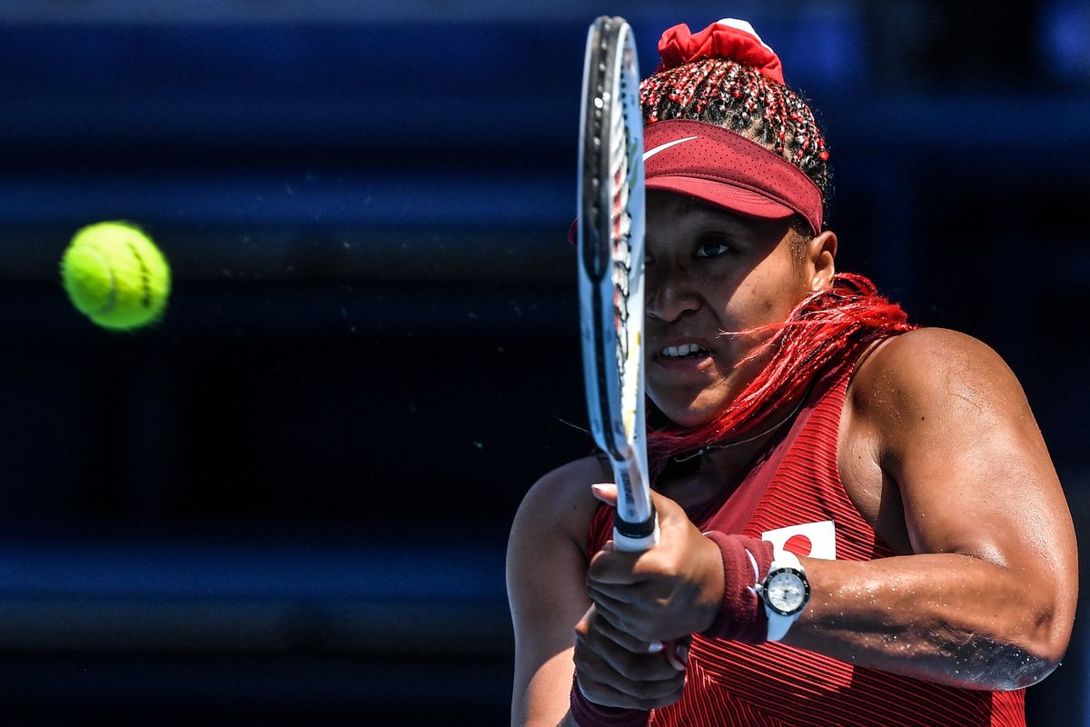 Petenis Jepang Naomi Osaka membalas pukulan ke pemain China Zheng Saisai dalam pertandingan tenis putaran pertama tunggal putri Olimpiade Tokyo 2020 di Ariake Tennis Park di Tokyo pada 25 Juli 2021.