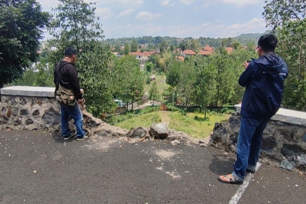 Dua orang jurnalis berada di tembok yang rusak setelah ditabrak mobil pick up dan terjun di lokasi objek wisata desa Setianegara Kecamatan Cilimus Kabupaten Kuningan, pada Senin (7/10/2024) siang