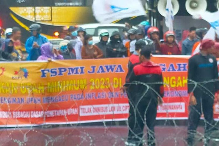 Puluhan buruh yang tergabung dalam Konfederasi Serikat Pekerja Indonesia (KSPI) Jawa Tengah rela menerjang hujan deras di depan gerbang Kantor Gubernur Jateng demi memperjuangkan kenaikan upah, Jumat (4/11/2022).