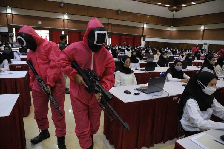 Petugas memakai kostum seperti Squid Game menjaga tes CPNS Kemenkumham di kampus Untag Surabaya, Rabu (20/10/2021).