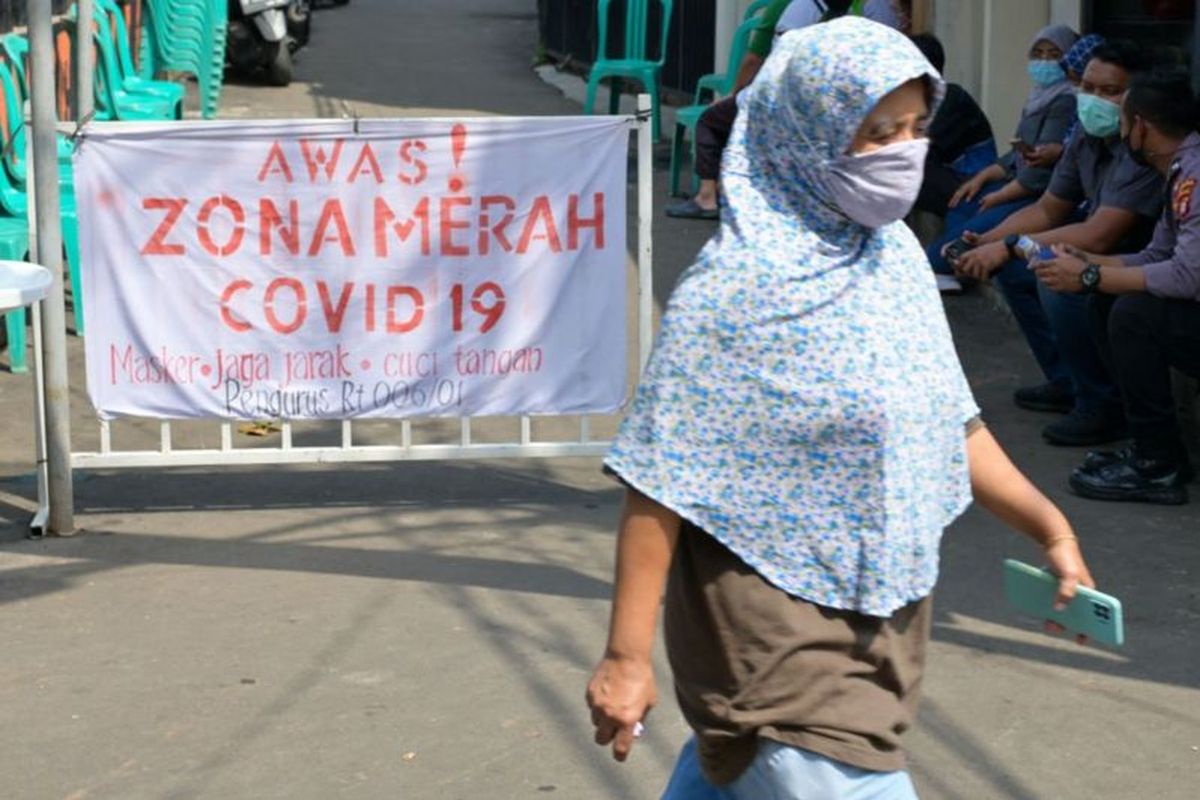 Seorang berjalan di lingkungan yang menjadi zona merah Covid-19 di Jakarta