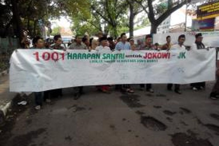 Ratusan santri yang tergabung dalam Laskar Santri Nusantara Jawa Barat menuliskan harapan untuk pasangan Calon Presiden dan Calon Wakil Presiden RI, Joko Widodo (Jokowi) - Jusuf Kalla (JK) di atas sebuah kain sepanjang 100 meter yang dibentangkan di Jalan Sancang, Kecamatan Buahbatu, Kota Bandung, Senin (26/5/2014).