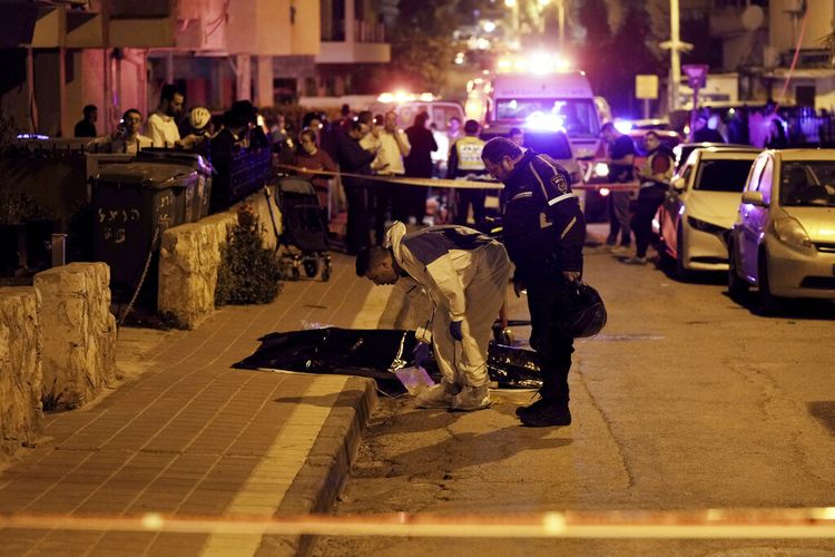 Polisi Israel memeriksa jenazah korban penembakan di Bnei Brak, Israel, Selasa, 29 Maret 2022. Belum diketahui pasti kronologis kejadian maut di kota timur Tel Aviv itu.