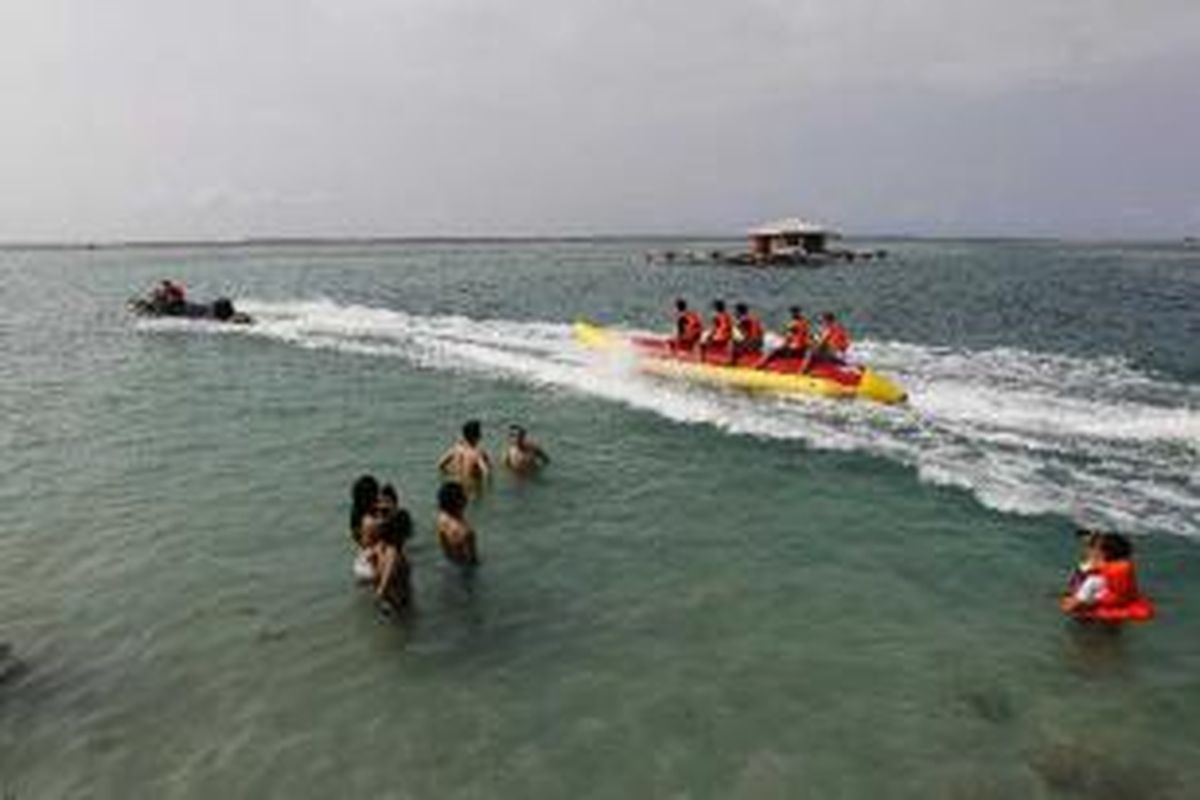 Wisatawan berenang dan bermain 'banana boat' di pantai Pulau Tidung, Kepulauan Seribu, Sabtu (14/5/2011). Pulau ini kian dikenal sebagai salah satu destinasi wisata bahari. Pada hari libur, pulau yang memiliki lebar sekitar 200 meter dan panjang hanya 5 kilometer, ini ramai dikunjungi wisatawan.