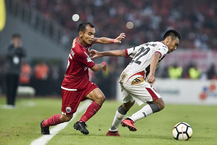 Pesepak bola Persija Jakarta Riko Simanjuntak (kiri) berebut bola dengan pesepak bola Mitra Kukar FC Dedy Hartono (kanan) dalam pertandingan liga 1 2018, Stadion Utama Gelora Bung Karno, Jakarta, Minggu (9/12/2018). Persija Jakarta berhasil mengalahkan Mitra Kukar FC dengan skor 2-1 dan memastikan juara Liga 1 2018.